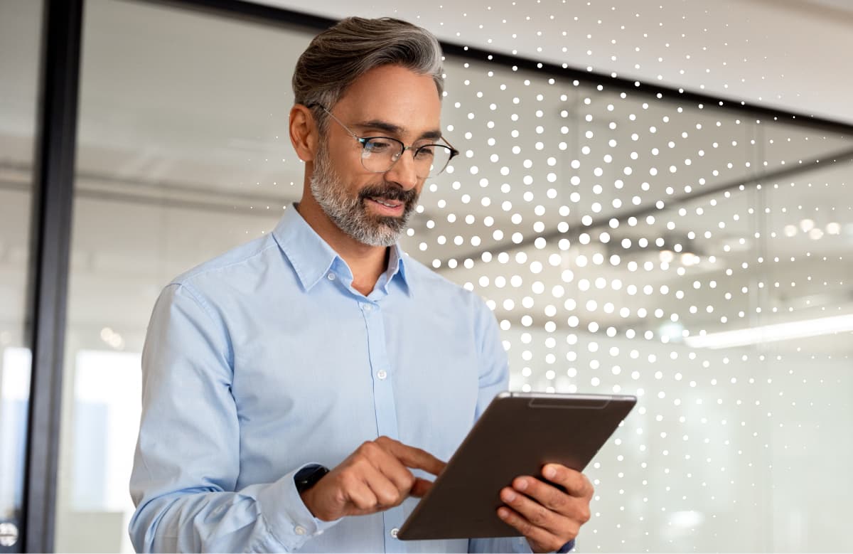 Man Wearing Glasses Holding Tablet In Modern Office