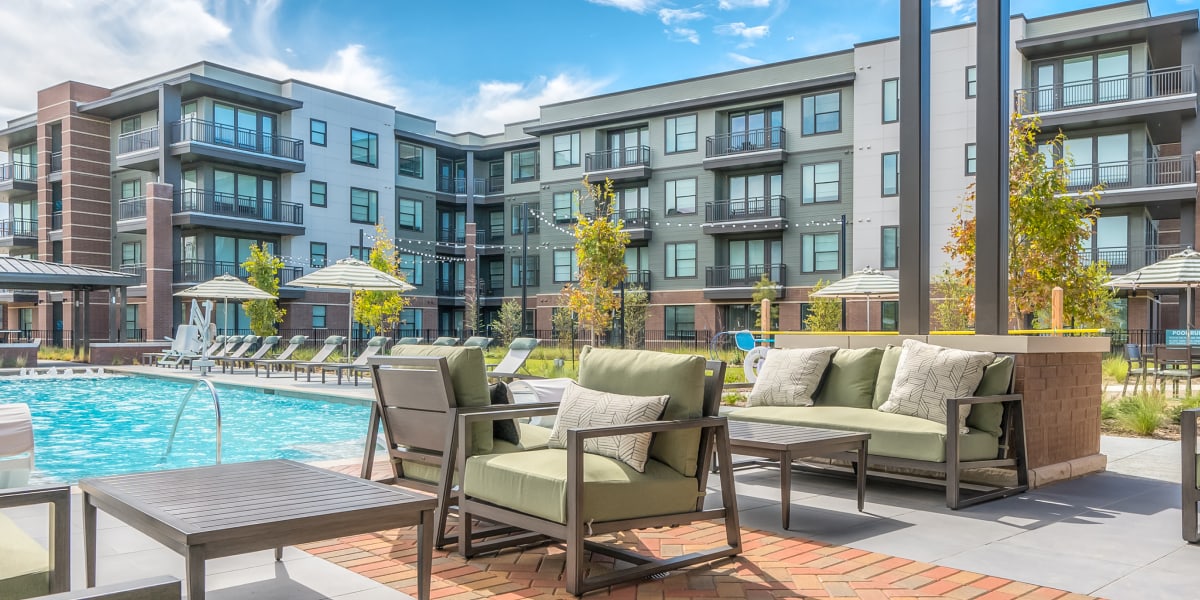 Modern Apartment Complex Pool Deck With Lounge Seating And Green Cushions