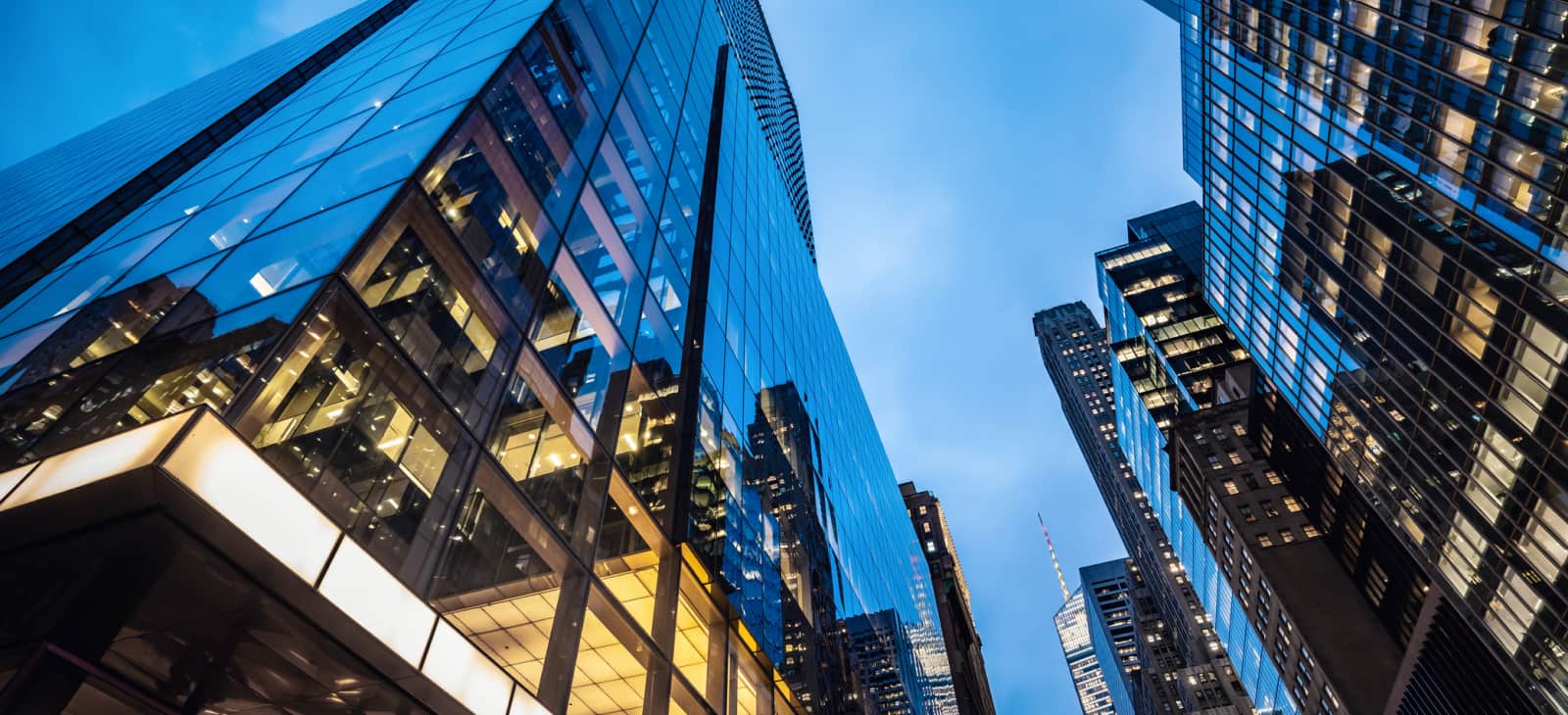 Modern Glass And Steel Skyscrapers Lit At Dusk In City Street