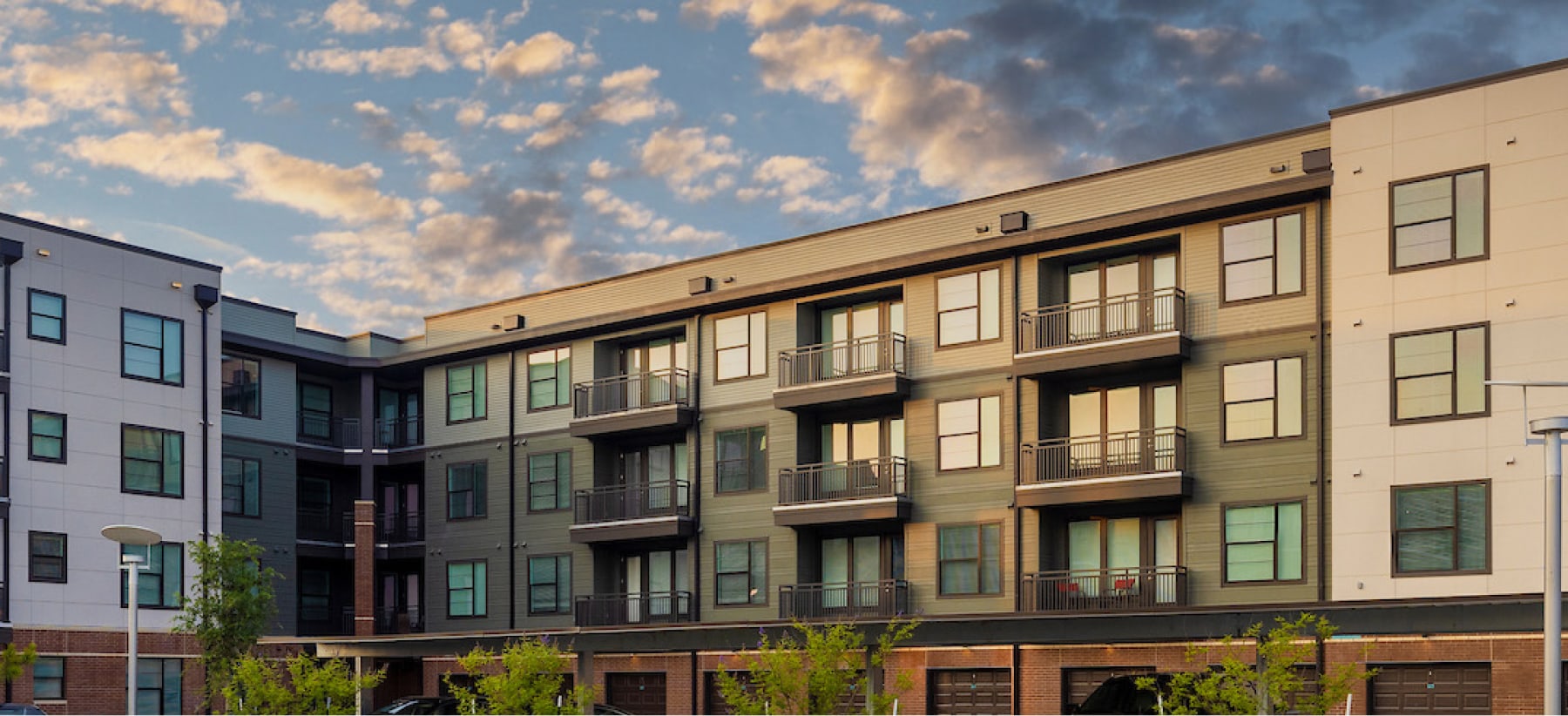 Modern Multi Story Apartment Buildings With Balconies Under Cloudy Sky Hero