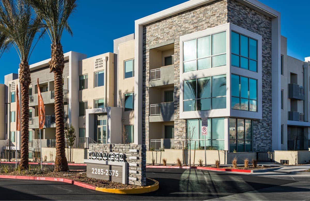 Modern Multistory Apartment Complex With Stone And Stucco Exterior Palm Trees
