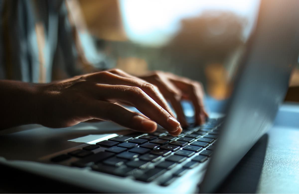 Person Typing On Laptop Keyboard With Digital Data Visualization