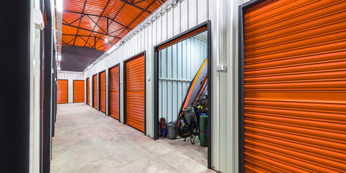 Self Storage Facility Interior With Orange Metal Roll Up Doors And Bike Stored In Unit
