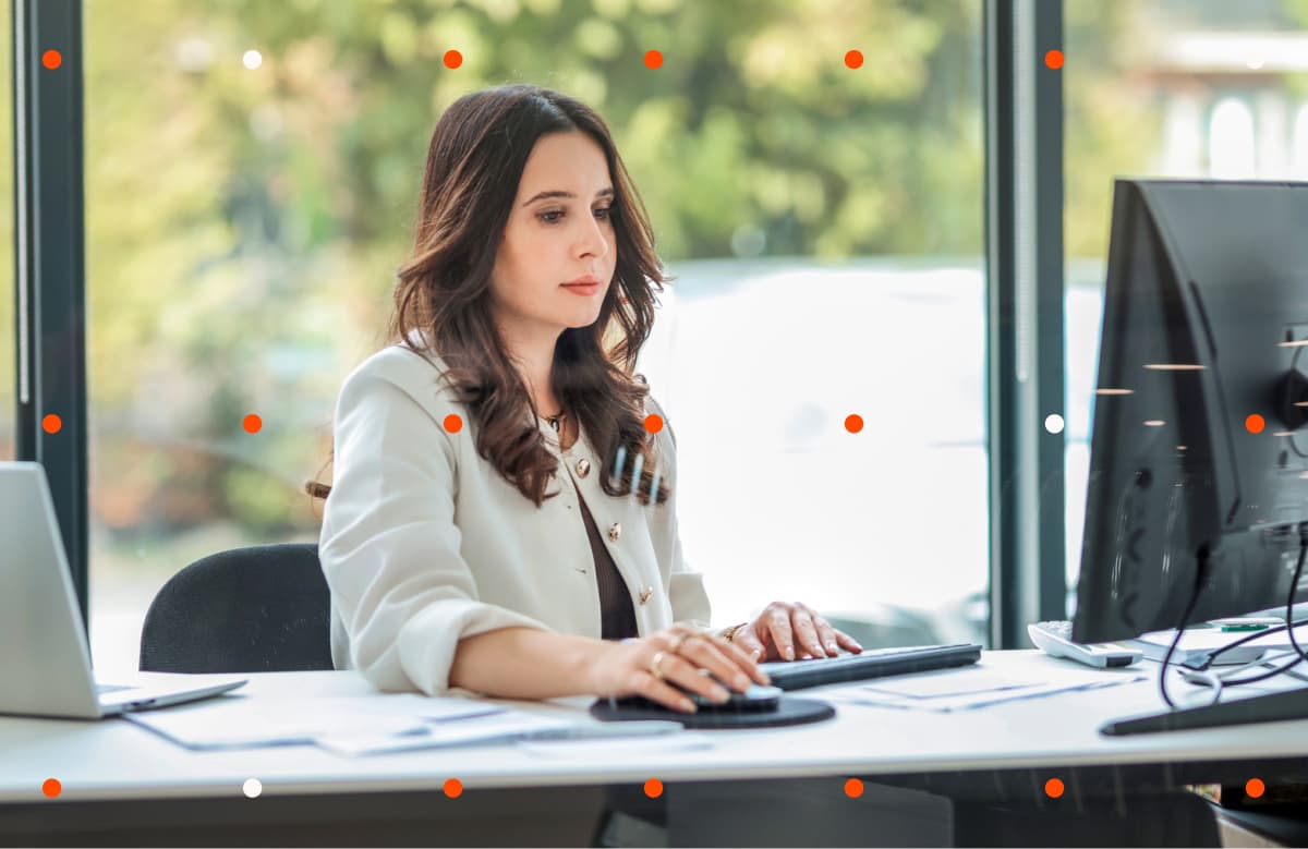 Woman In White Blazer Typing On Keyboard At Office Desk